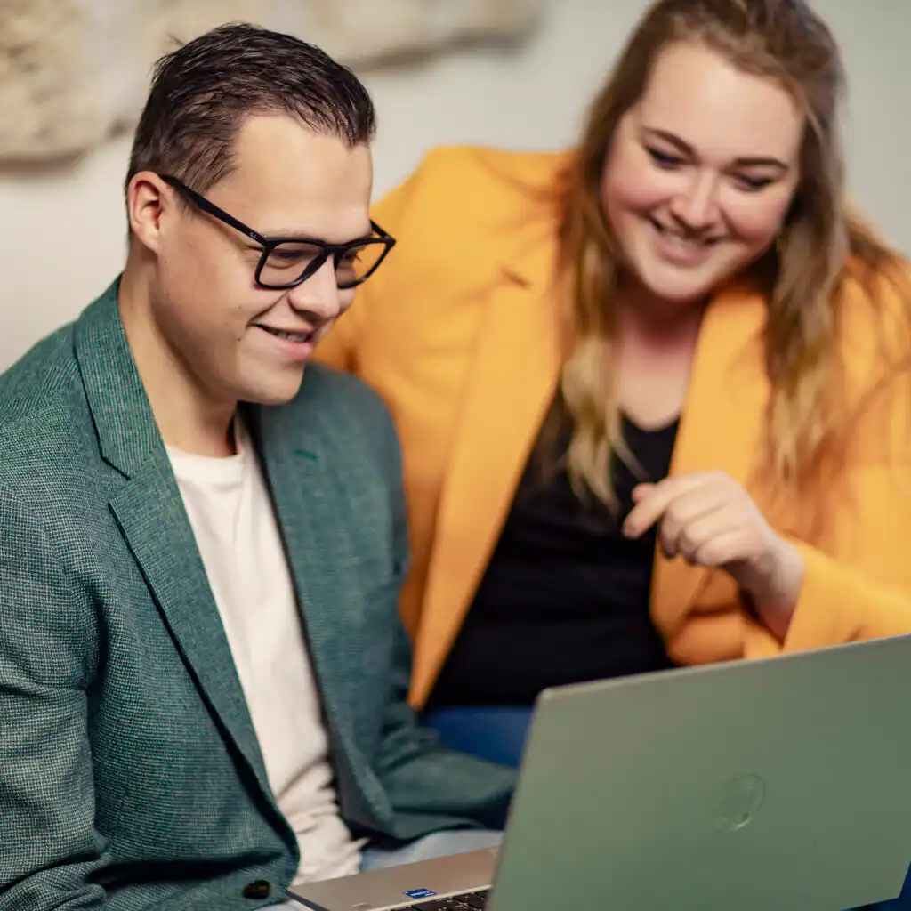 Twee personen die op een laptop met Intramed werken
