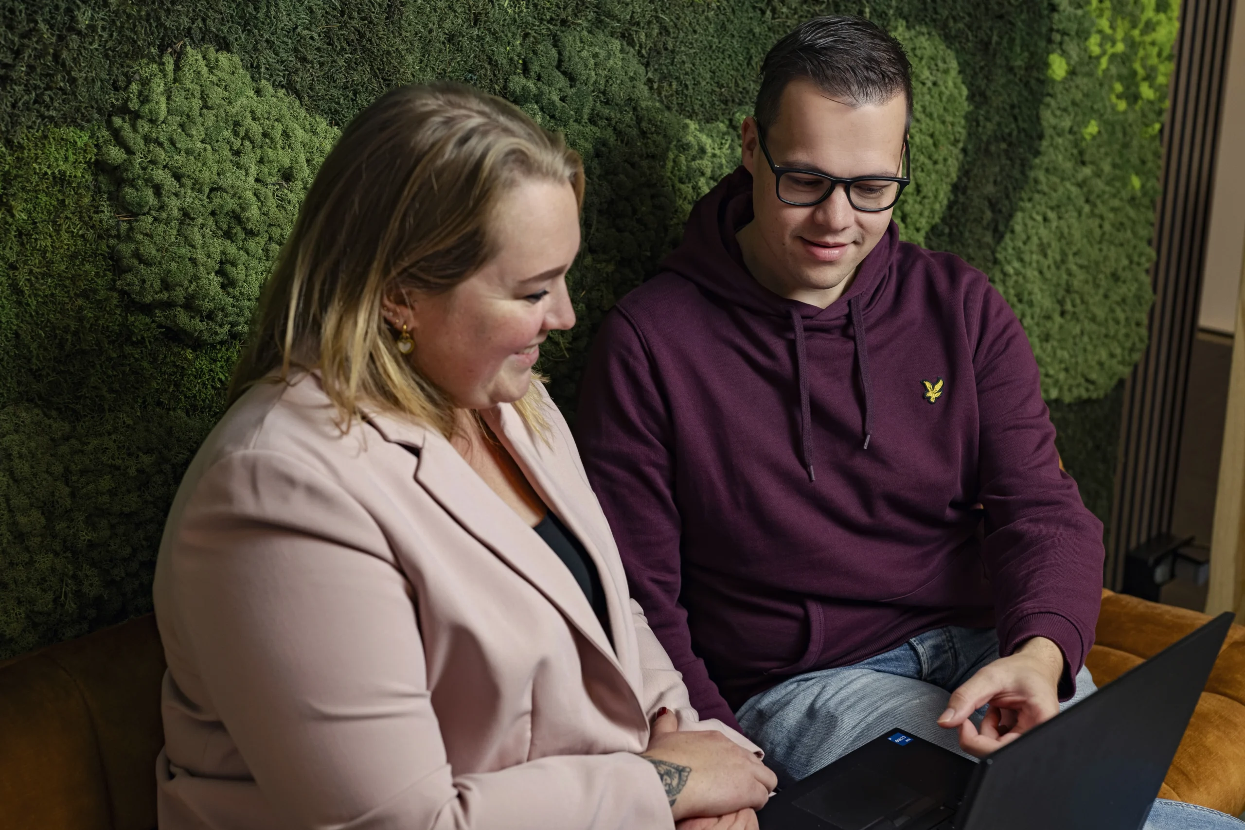 Twee medewerkers van Intramed kijken naar laptop
